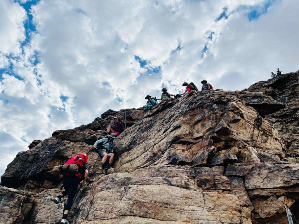 Hikers descending into Fish River Canyon on a rocky trail during a multi-day hike