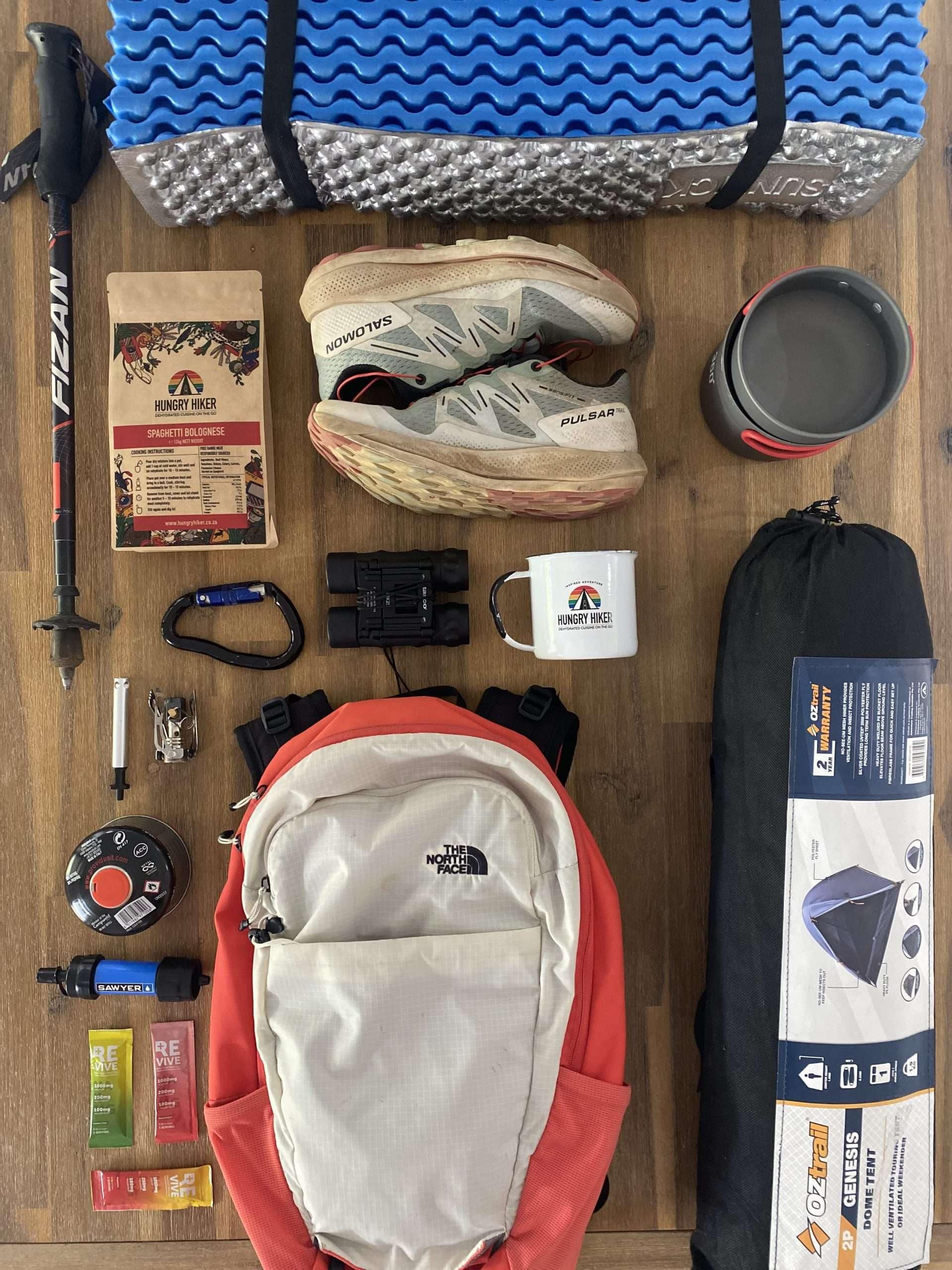 Multi-day hiking gear and dehydrated meal laid out for a backpacking trip
