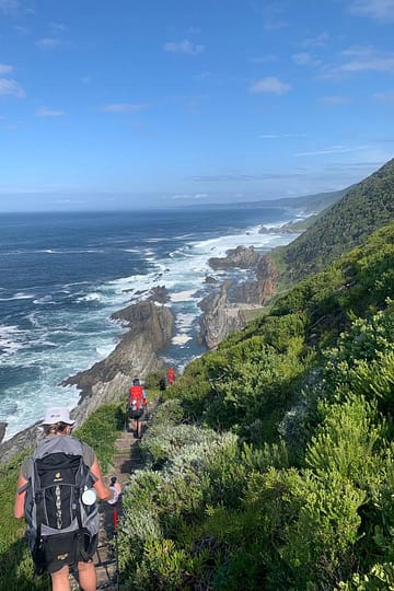 Hikers walking along the Otter Trail coastal path with ocean views in South Africa