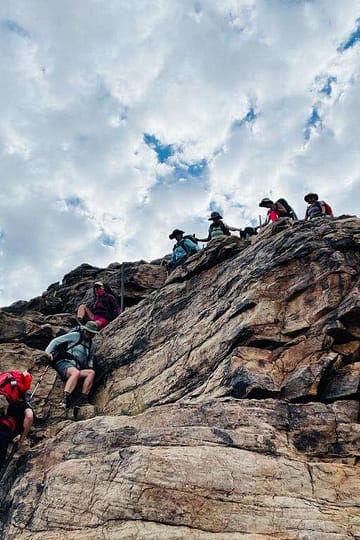 Hikers descending into Fish River Canyon on a rocky trail during a multi-day hike