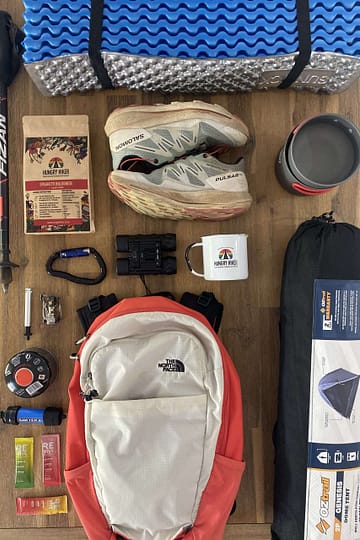 Multi-day hiking gear and dehydrated meal laid out for a backpacking trip