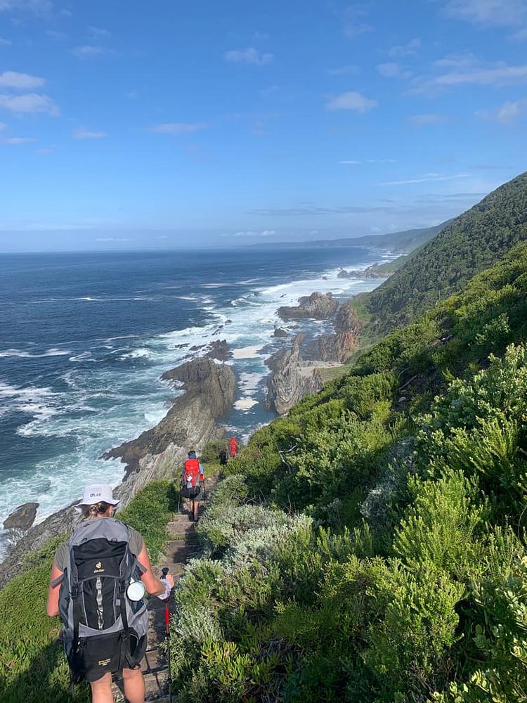 Hikers walking along the Otter Trail coastal path with ocean views in South Africa